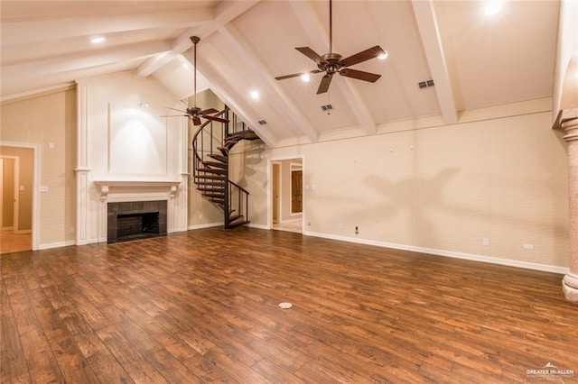 unfurnished living room featuring dark hardwood / wood-style floors, high vaulted ceiling, a fireplace, ceiling fan, and beam ceiling