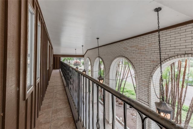 corridor with light tile patterned flooring and brick wall