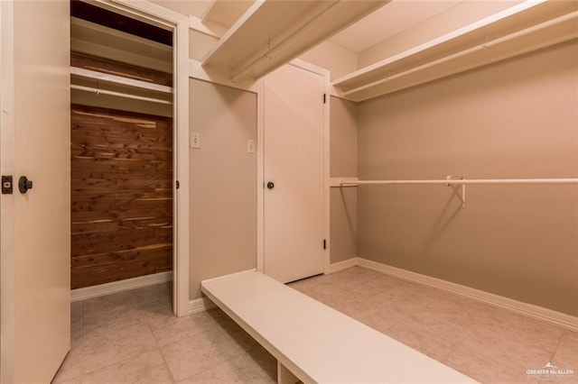 interior space featuring light tile patterned floors and wood walls