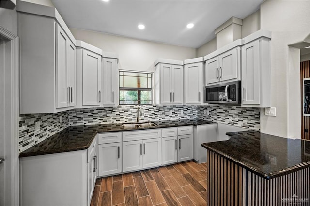 kitchen featuring recessed lighting, stainless steel microwave, a sink, and tasteful backsplash