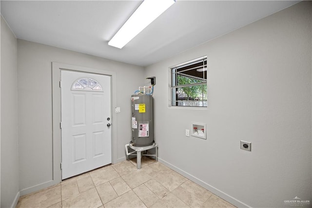 entryway with baseboards, light tile patterned flooring, and electric water heater