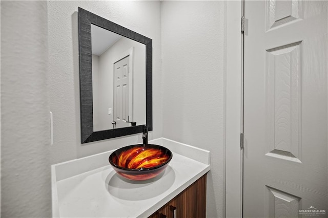 bathroom with vanity and a textured wall