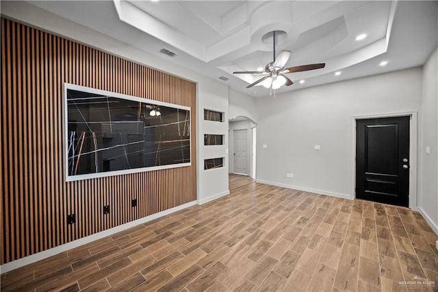 empty room with a ceiling fan, visible vents, arched walkways, wood finished floors, and recessed lighting