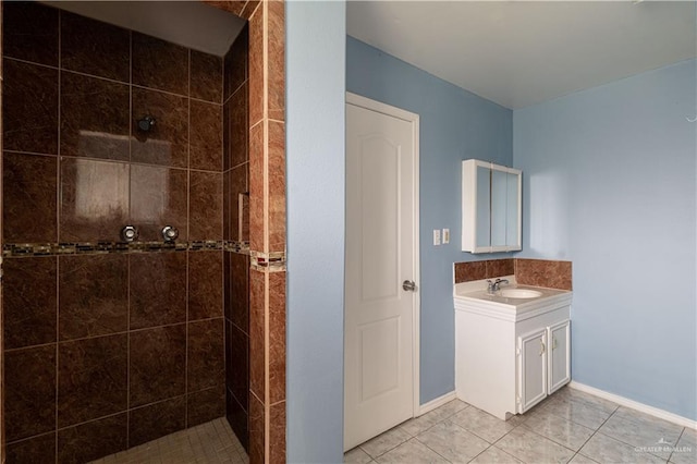 bathroom with a tile shower, tile patterned floors, and vanity