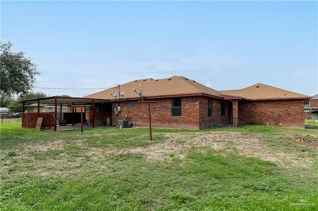 rear view of house featuring a patio, central AC unit, and a lawn