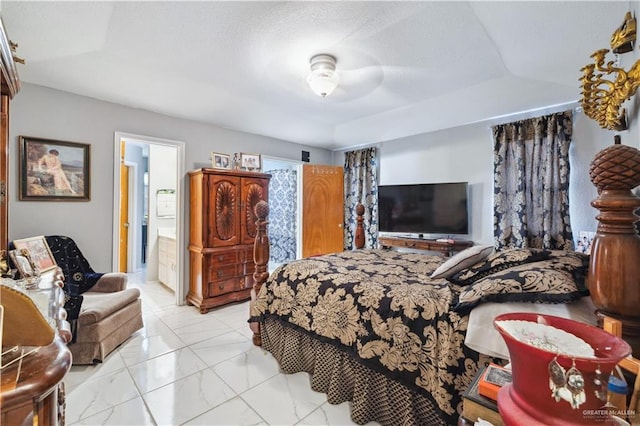 bedroom with light marble finish floors and ensuite bath