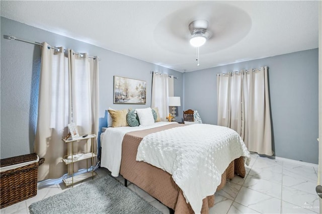 bedroom featuring light marble finish floors and a ceiling fan