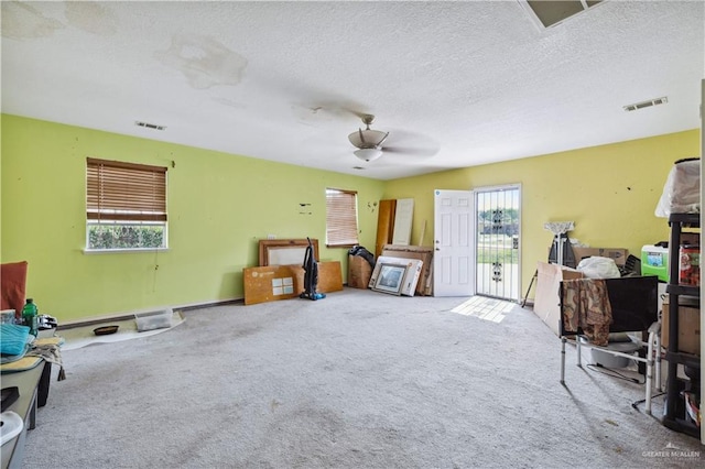 sitting room with carpet flooring, a textured ceiling, and ceiling fan