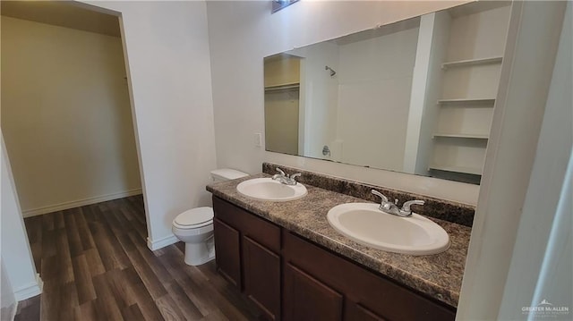 bathroom with toilet, hardwood / wood-style flooring, and vanity