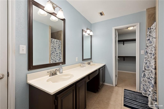 bathroom featuring tile patterned flooring, vanity, and walk in shower