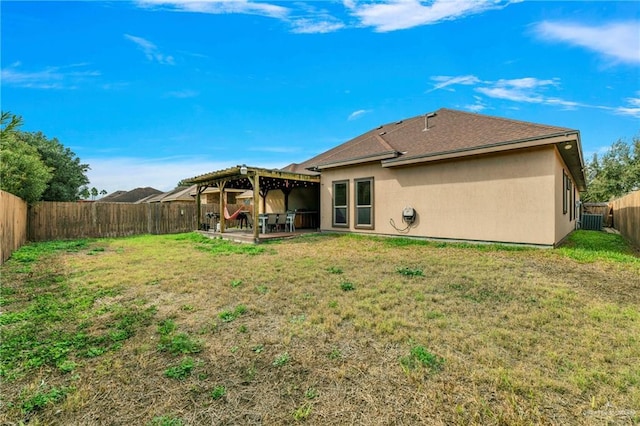 back of property with central AC unit, a yard, and a patio