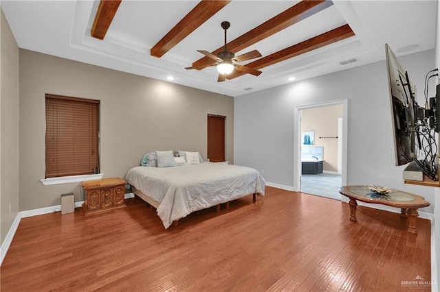 bedroom featuring ensuite bathroom, light wood-type flooring, a raised ceiling, beamed ceiling, and ceiling fan