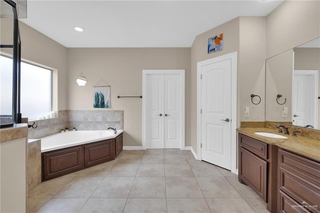 bathroom with vanity, tile patterned flooring, and a washtub