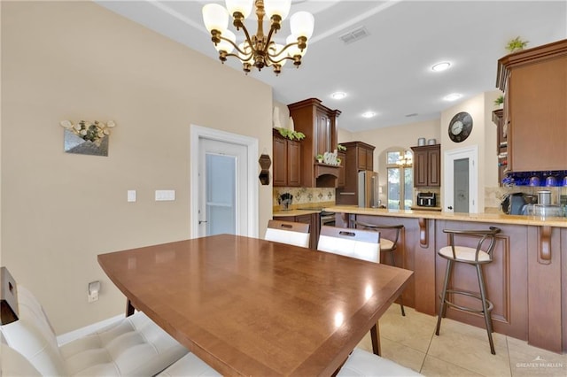 tiled dining space with an inviting chandelier