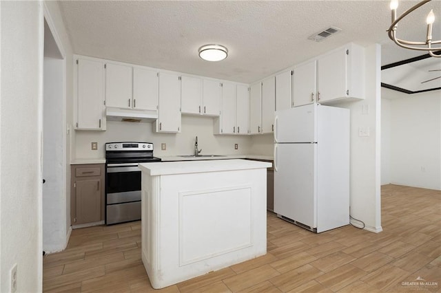 604 N Padre Ave, Weslaco, TX 78596 - kitchen featuring freestanding refrigerator, stainless steel electric range, under cabinet range hood, light wood-type flooring, and white cabinetry