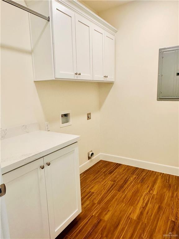 clothes washing area with cabinets, hookup for a washing machine, electric dryer hookup, electric panel, and dark hardwood / wood-style floors