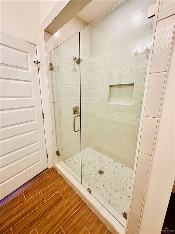2110 Trinity, Donna, TX 78537 - full bathroom featuring wood finished floors and a stall shower