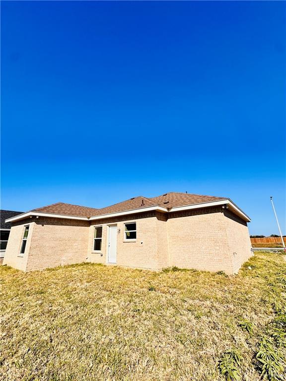 rear view of property with a yard