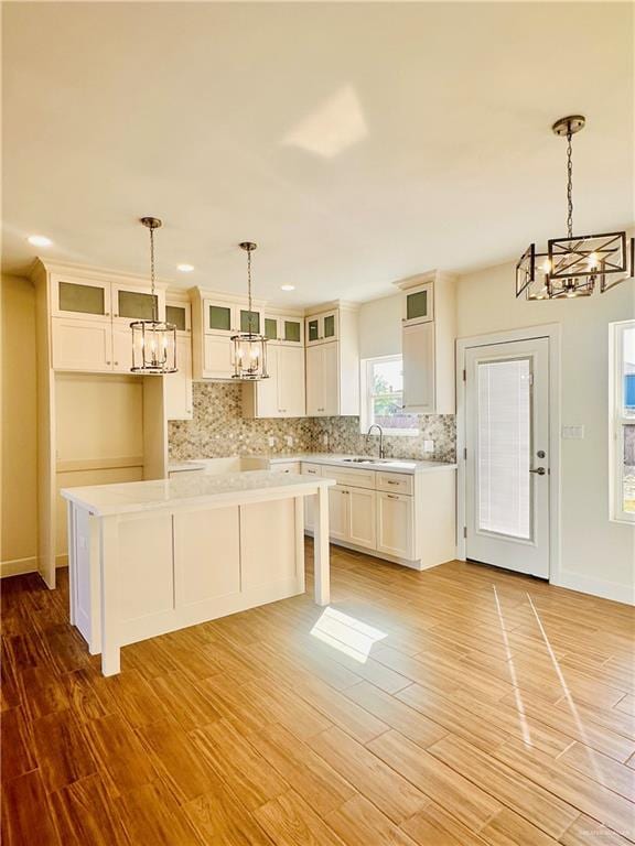 kitchen featuring decorative light fixtures, a kitchen island, and light hardwood / wood-style flooring