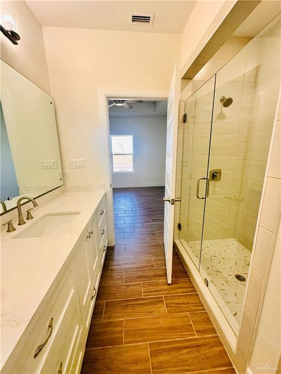 bathroom featuring vanity and a shower with shower door