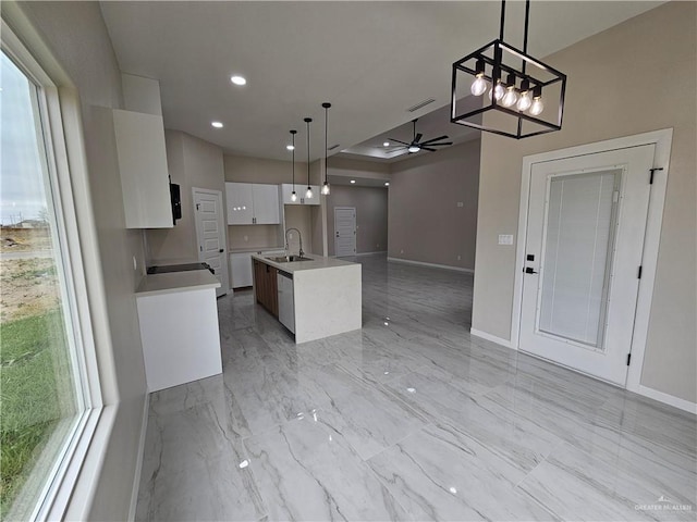 kitchen featuring a center island with sink, sink, ceiling fan, white cabinets, and hanging light fixtures