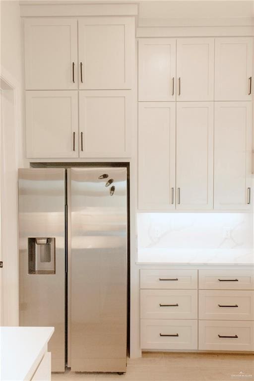 kitchen with light countertops, white cabinets, and stainless steel fridge with ice dispenser