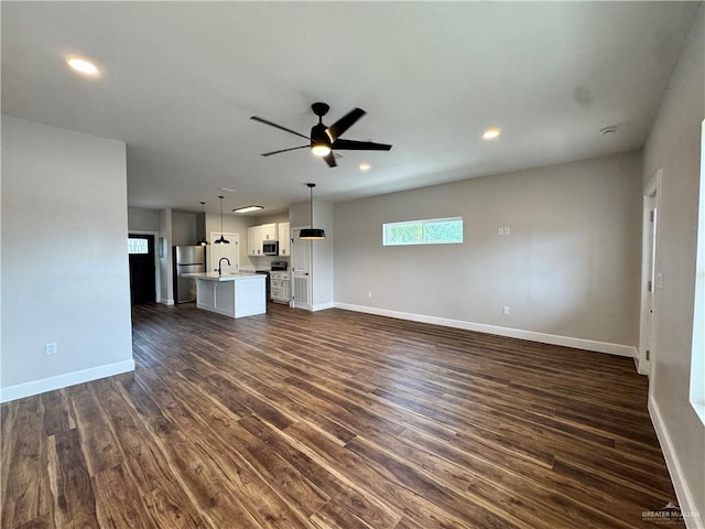 1604 Monterrey Cir, Brownsville, TX 78526 - unfurnished living room with dark wood-style flooring, ceiling fan, and recessed lighting