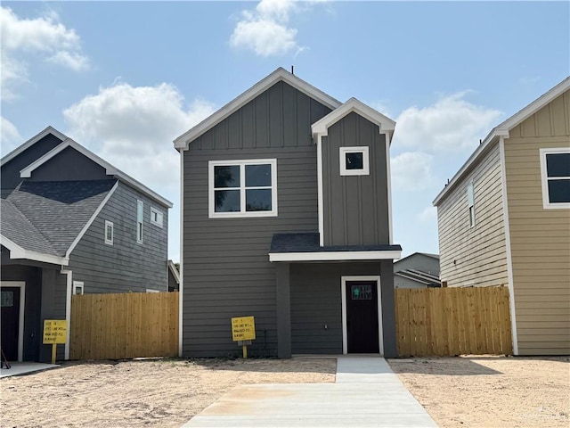 modern home featuring fence and board and batten siding