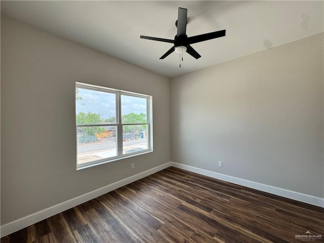 spare room with a ceiling fan, baseboards, and dark wood-style floors