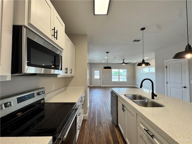 1604 Monterrey Cir, Brownsville, TX 78526 - kitchen with stainless steel appliances, dark wood finished floors, white cabinets, decorative light fixtures, and recessed lighting