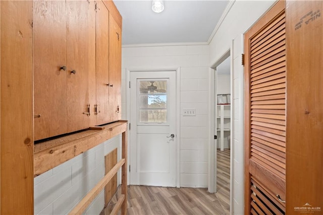 entryway featuring ornamental molding and light hardwood / wood-style floors