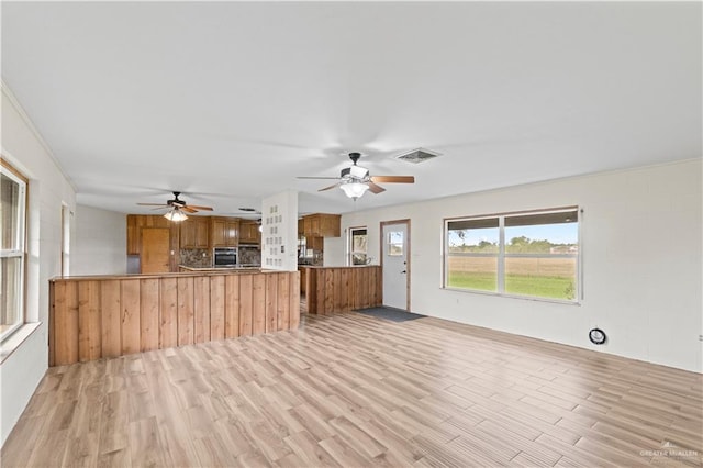 unfurnished living room with light hardwood / wood-style flooring and ceiling fan