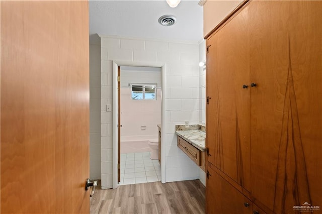 bathroom featuring toilet, hardwood / wood-style flooring, and vanity