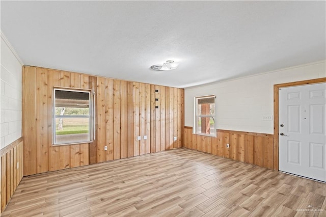 spare room featuring light hardwood / wood-style flooring and wooden walls