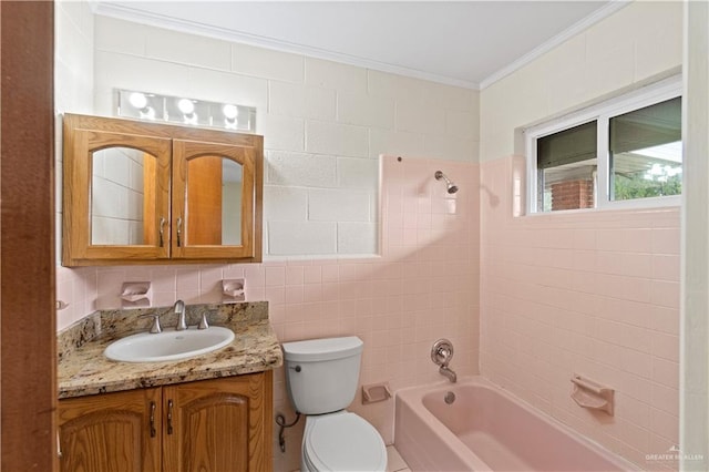 full bathroom featuring tiled shower / bath, vanity, crown molding, and toilet