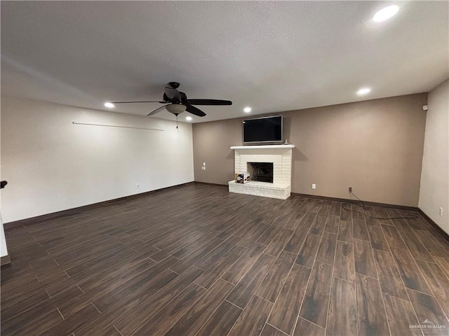 1060 Timothy St, San Benito, TX 78586 - unfurnished living room featuring a ceiling fan, dark wood-type flooring, a brick fireplace, and recessed lighting