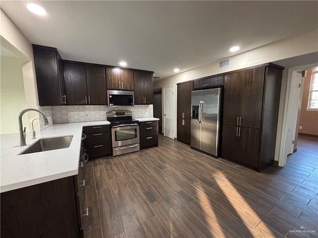 1060 Timothy St, San Benito, TX 78586 - kitchen with stainless steel appliances, light countertops, dark brown cabinets, backsplash, and recessed lighting