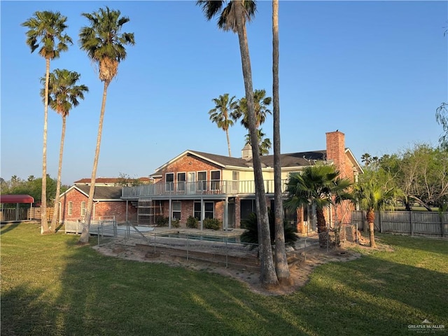 1060 Timothy St, San Benito, TX 78586 - back of property featuring brick siding, a balcony, and a chimney