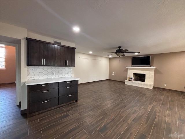 1060 Timothy St, San Benito, TX 78586 - unfurnished living room with ceiling fan, dark wood-type flooring, recessed lighting, and a fireplace