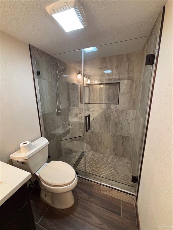 1060 Timothy St, San Benito, TX 78586 - bathroom with vanity, a textured ceiling, wood finished floors, and a stall shower