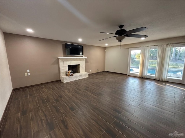 1060 Timothy St, San Benito, TX 78586 - unfurnished living room featuring dark wood finished floors, ceiling fan, recessed lighting, and a fireplace