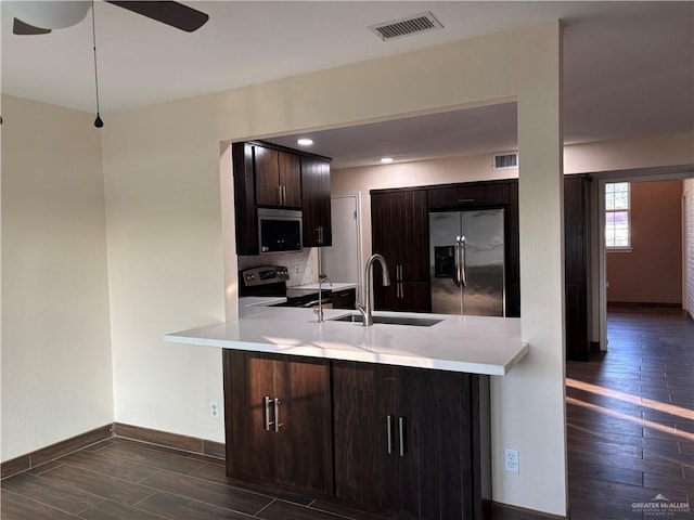 1060 Timothy St, San Benito, TX 78586 - kitchen featuring appliances with stainless steel finishes, a peninsula, dark wood-type flooring, light countertops, and recessed lighting
