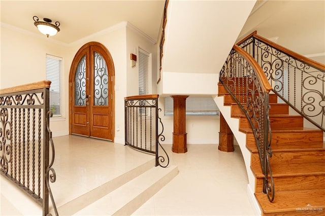 foyer entrance featuring french doors and crown molding