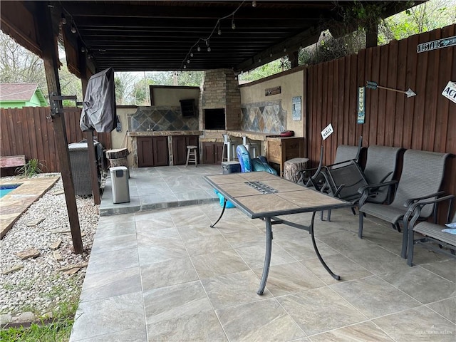 view of patio with exterior fireplace