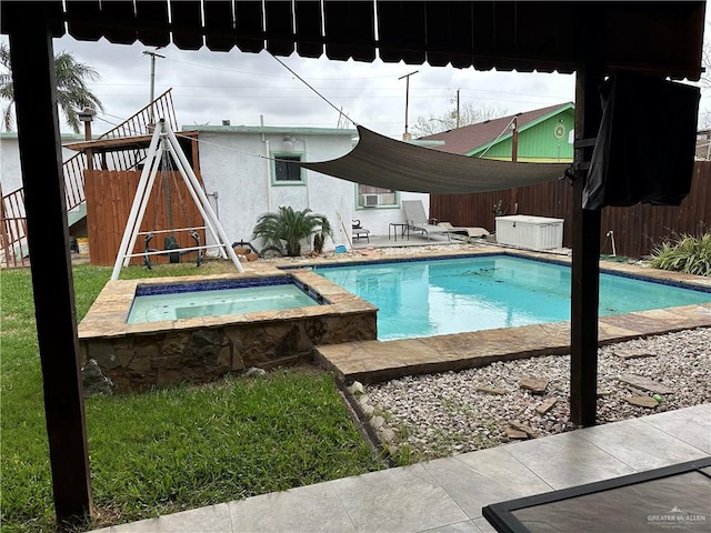 view of swimming pool featuring an in ground hot tub and a patio area