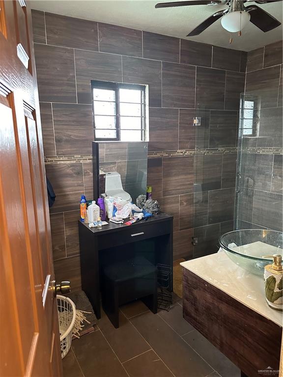 bathroom featuring tile patterned floors, ceiling fan, and a tile shower