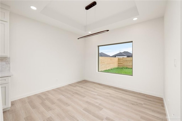3508 E Kidd Ave, Edinburg, TX 78542 - spare room featuring light wood-style floors, recessed lighting, a tray ceiling, and baseboards