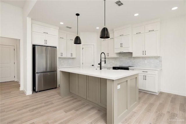 3508 E Kidd Ave, Edinburg, TX 78542 - kitchen featuring stainless steel refrigerator, a sink, light countertops, light wood-style flooring, and white cabinetry