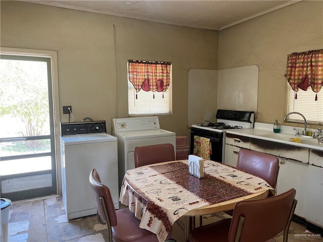 kitchen with white cabinetry, washing machine and dryer, sink, and range with gas cooktop