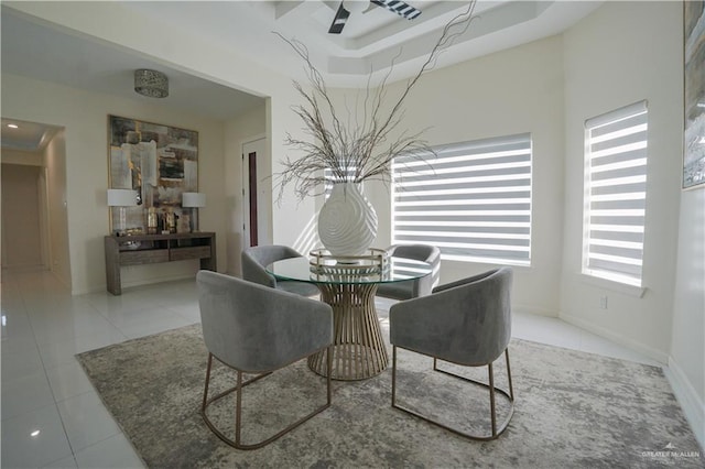 dining area with baseboards, a high ceiling, and tile patterned flooring